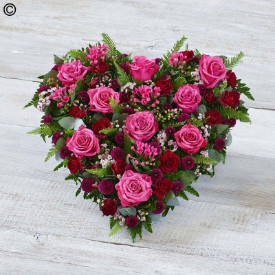 Cerise Rose Heart - A heart tribute bursting with roses in rich pink and red tones.

Approximate Product Dimensions:
Standard:
Length: 52cm, Width: 45cm, Height: 15cm.