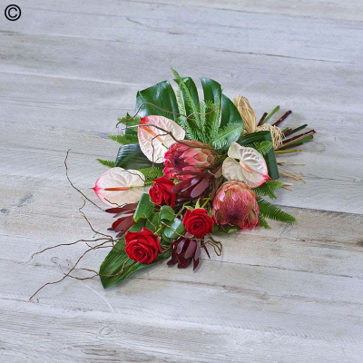 Tropical Sheaf - Vibrant blooms, including red roses and white anthuriums, meets rich foliage including a monstera leaf and umbrella fern.

Approximate Product Dimensions:
Length: 70cm, Width: 30cm, Height: 20cm.